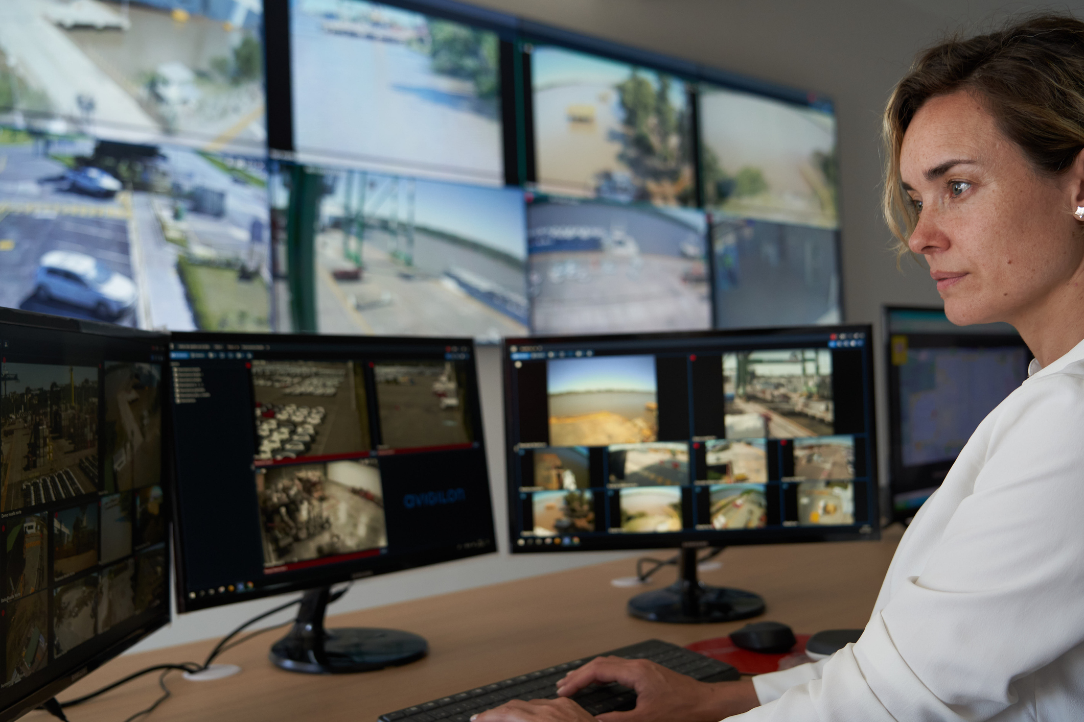 Adult female security worker watching monitors at control room